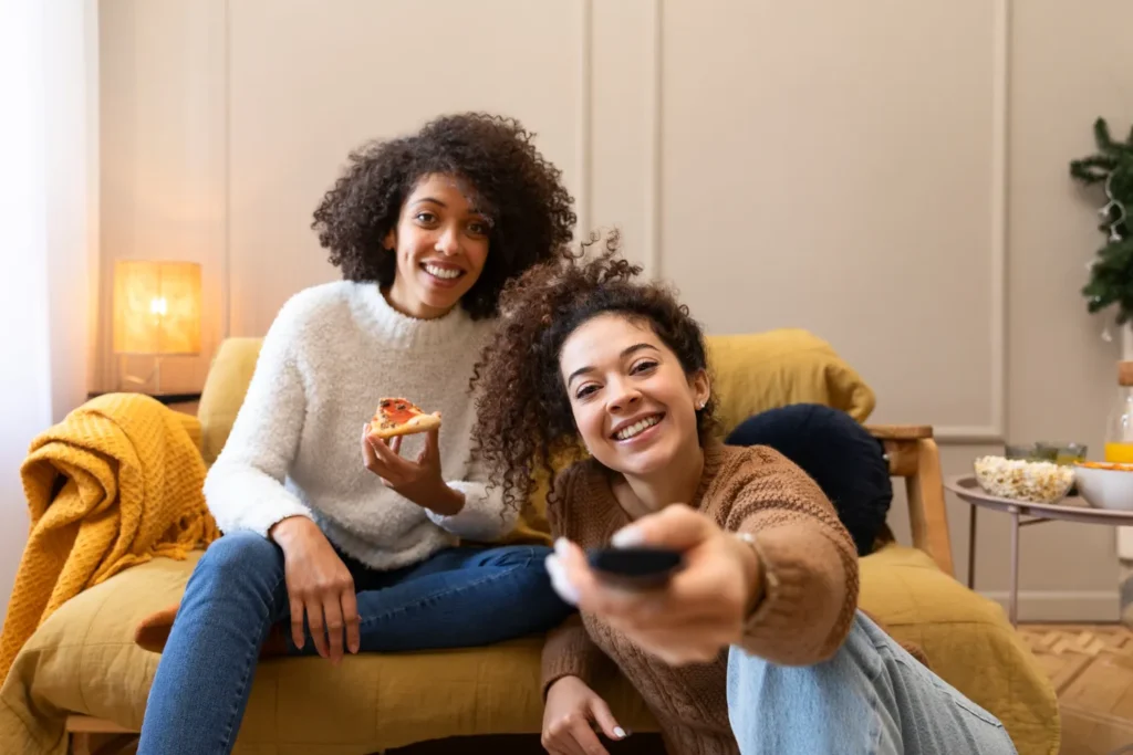 Deux amies regardant leurs chaînes belges via un forfait IPTV Belgique annuel
